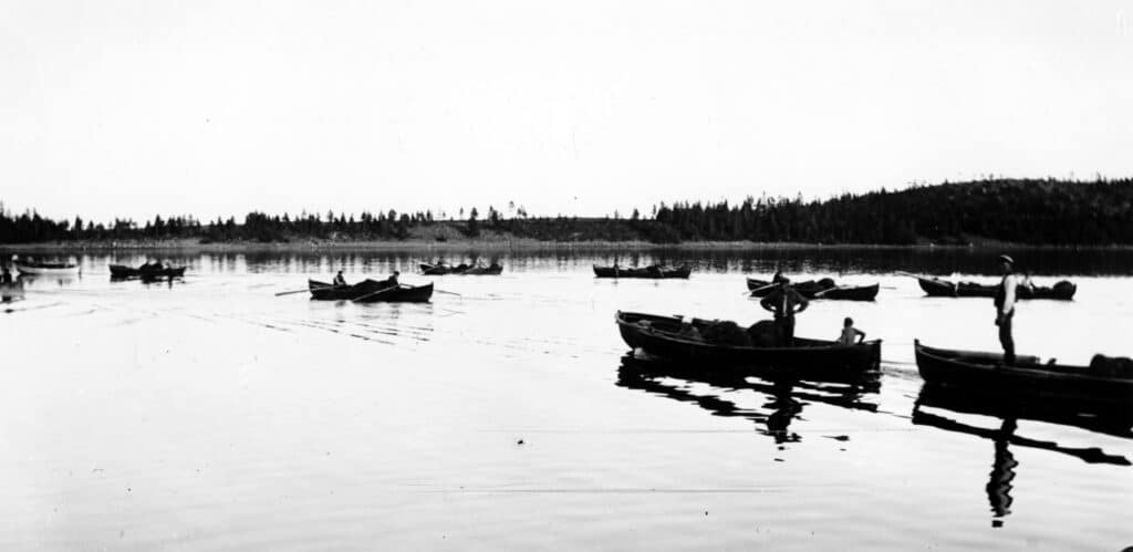 Bilden visar båtar som rors ut eller körs med motor. Havet är blankt.