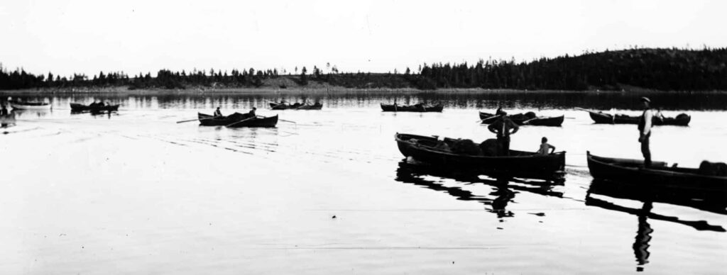 Båtar som rors ut eller körs med motor. Havet är blankt.