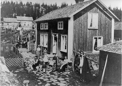 Äldre hus med människor framför husets långsida