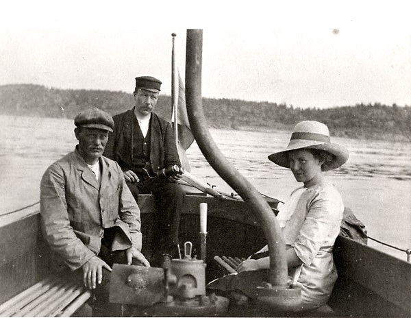 Bilden visar tre människor som sitter i en båt