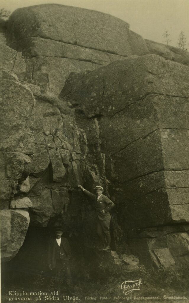 Bilden visar två män som står vid en klippformation