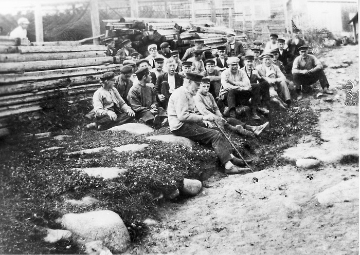 Bilden som är tagen 1918 visar män och pojkar som sitter i en backe.