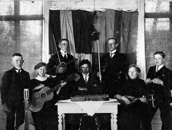 Bilden visar sju personer, unga och gamla och deras instrument