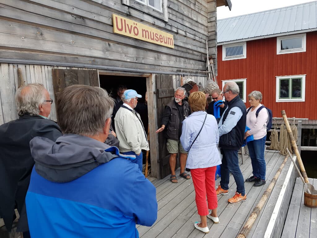 Bilden visar en grupp människor som guidas i Ulvö museum.