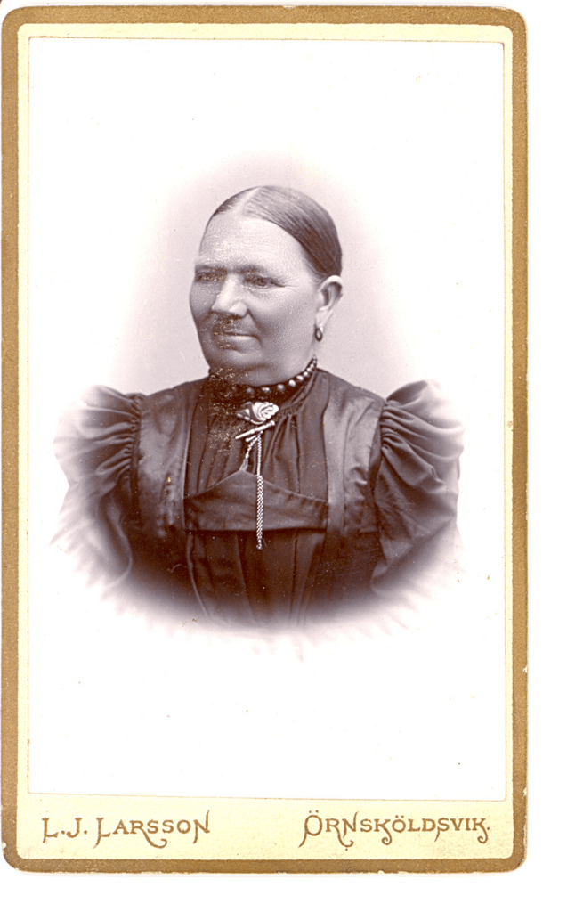 Bilden visar ett porträtt på en äldre kvinna med örhängen och fin klänning